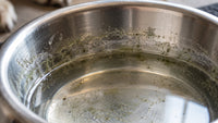 Dirty stainless steel pet water bowl showing residue and buildup 