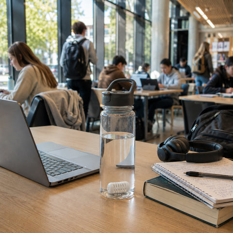 Reusable water bottle with GOpure Pod on a university study desk